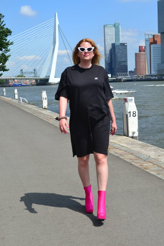 a girl look nice in oversized black t-shirt with pink shoes 